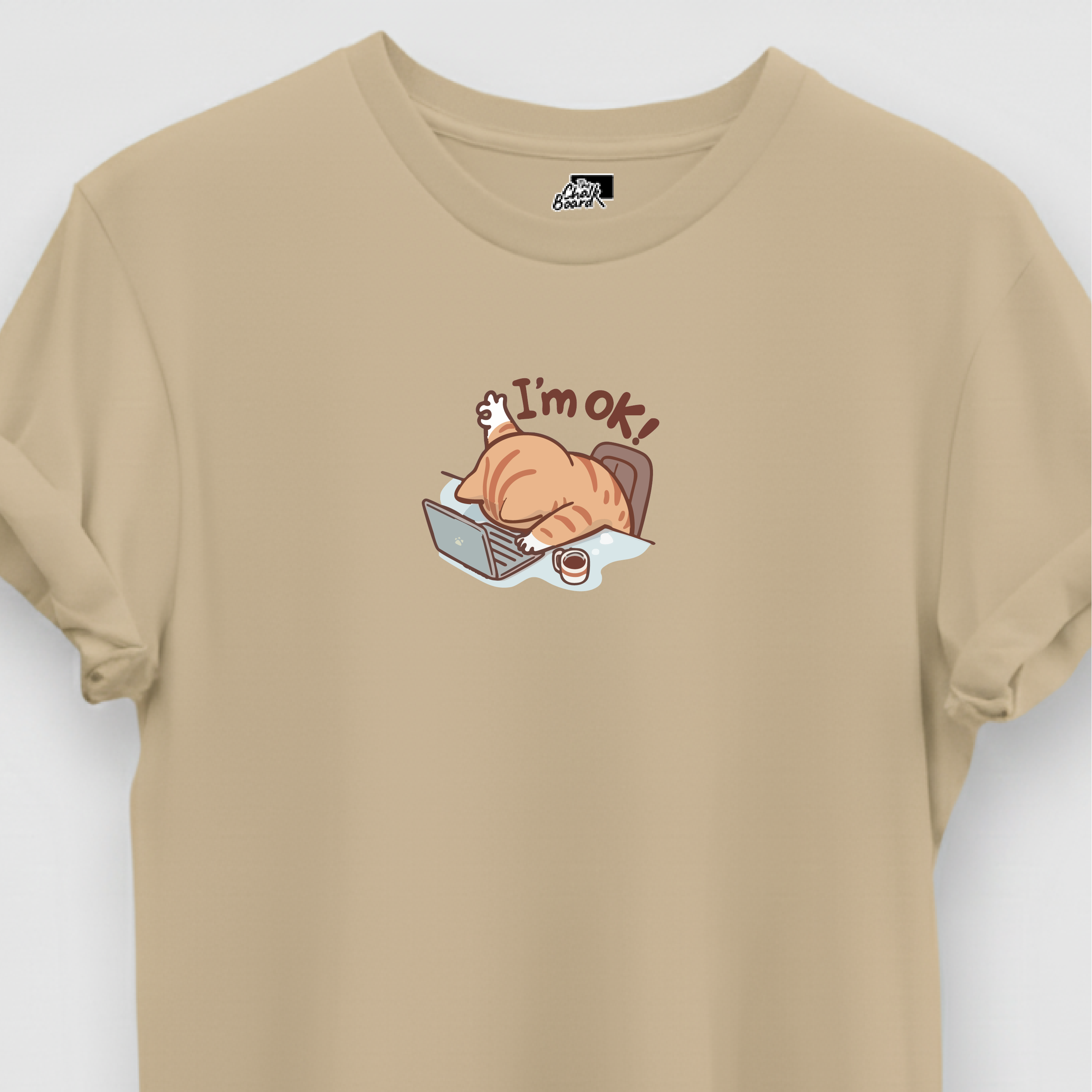 Beige t-shirt with a graphic of a cat and text 'I'm ok!' on a white background